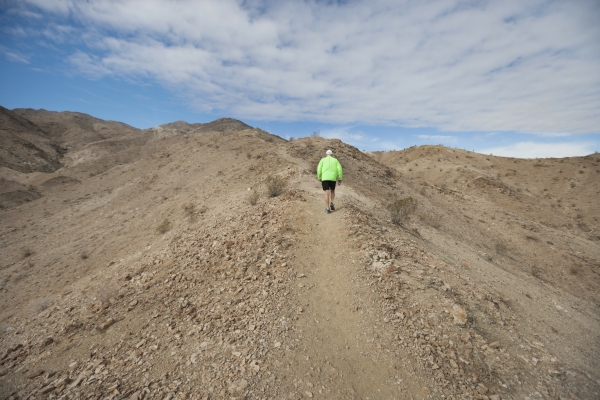 Man walking on a mountain trail.  5 life principles.  Spiral of Leaders.