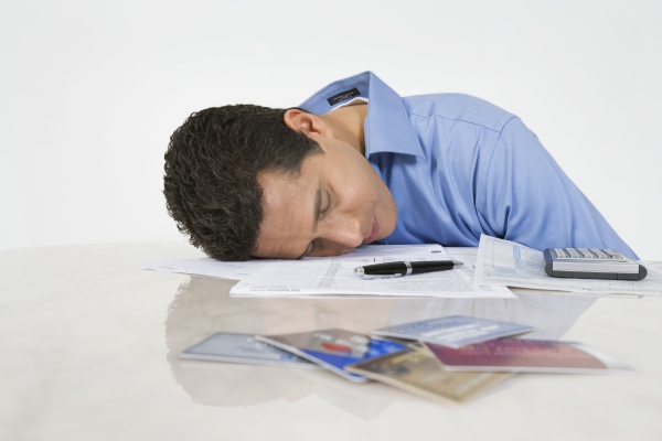 Exhausted man sleeping on bills