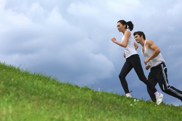 Young couple get in shape running up hill